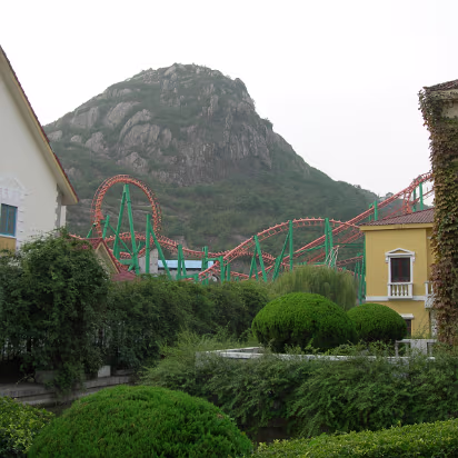Suzhou-2006-32 A nice shot showing the roller coaster and the mountains behind it.
