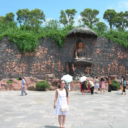 Ling-Shan-22 Hanhan in front of a copper fresco of the life of Buddha.