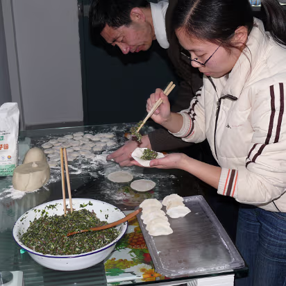 Spring-Festival-2007-016 Hanhan and her dad making the dumplings. He rolls the wrapper, she stuffs and seals them.